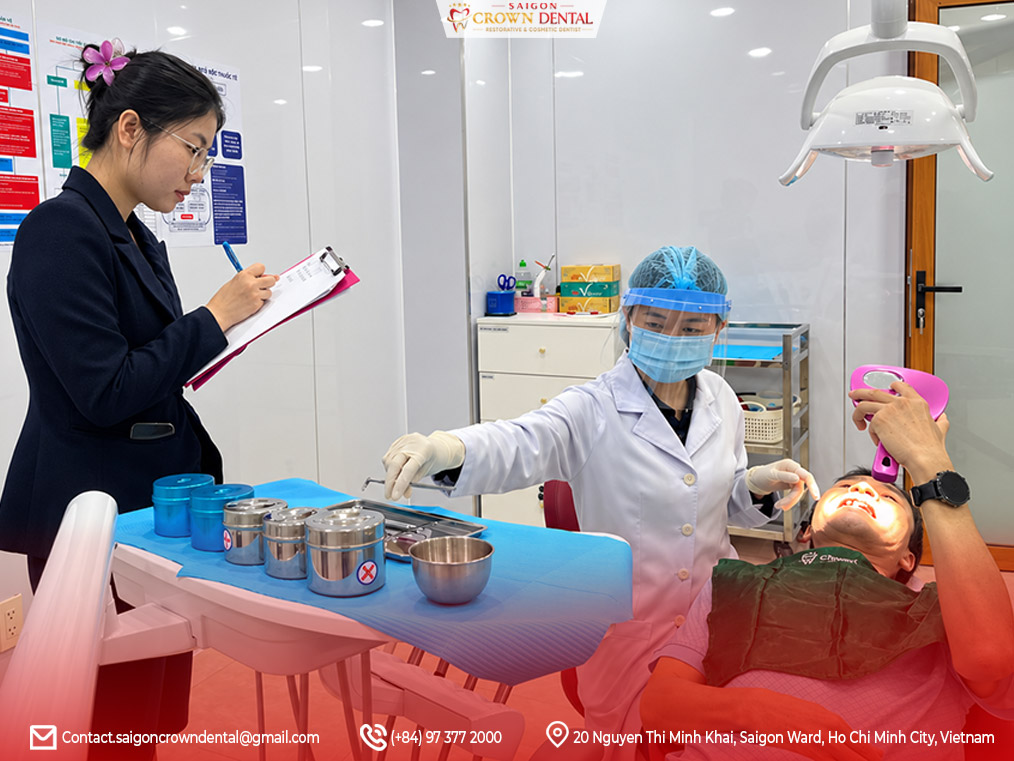 Bác sĩ tiến hành bước điều trị cuối cho bệnh nhân tại Nha khoa Quận 1 Bác sĩ thực hiện kiểm tra và gắn phục hình răng cho khách hàng tại Nha khoa Quận 1